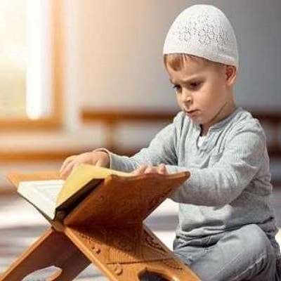 child is sitting and Try to Leaning Quran by Quran Qaidah