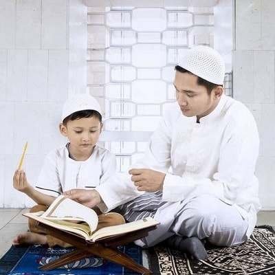 man is trying to teach Quran to child